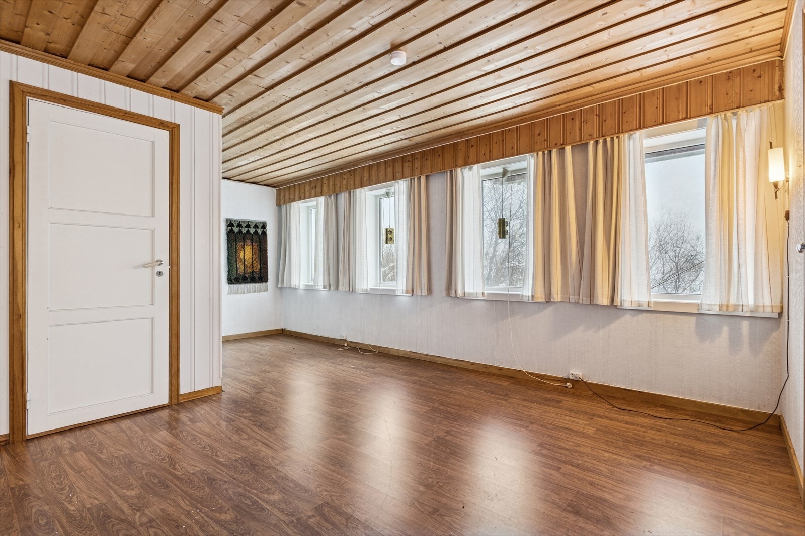 Trepanel i tak og laminatgulv gir et solid og varmt uttrykk i oppholdsrommet. Galleribilde