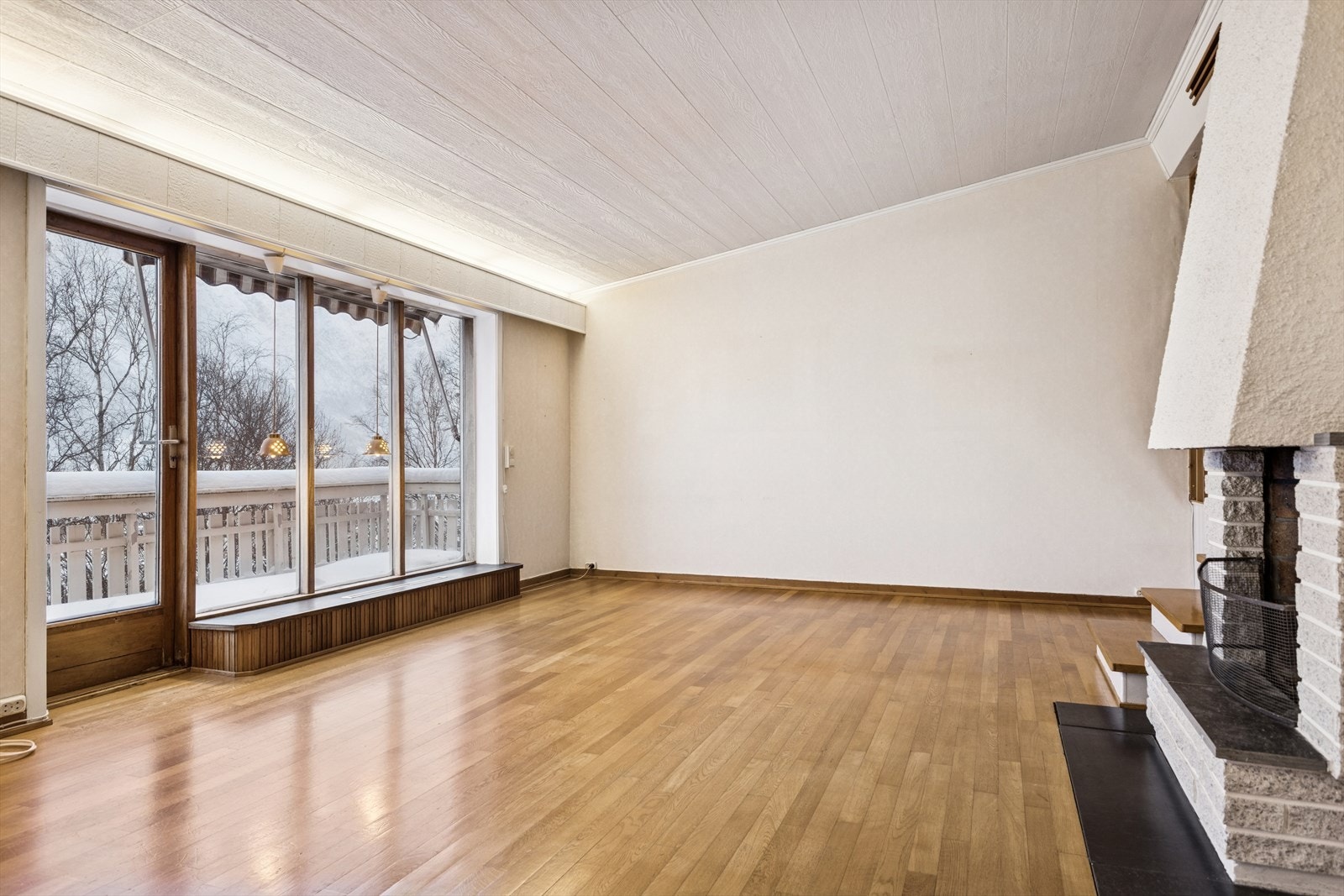 Parkettgulv og peis skaper et robust og funksjonelt oppholdsrom. Galleribilde