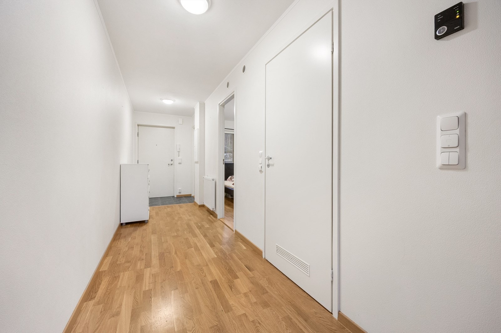 Velkommen inn i en lys gang som binder sammen leilighetens rom. Galleribilde