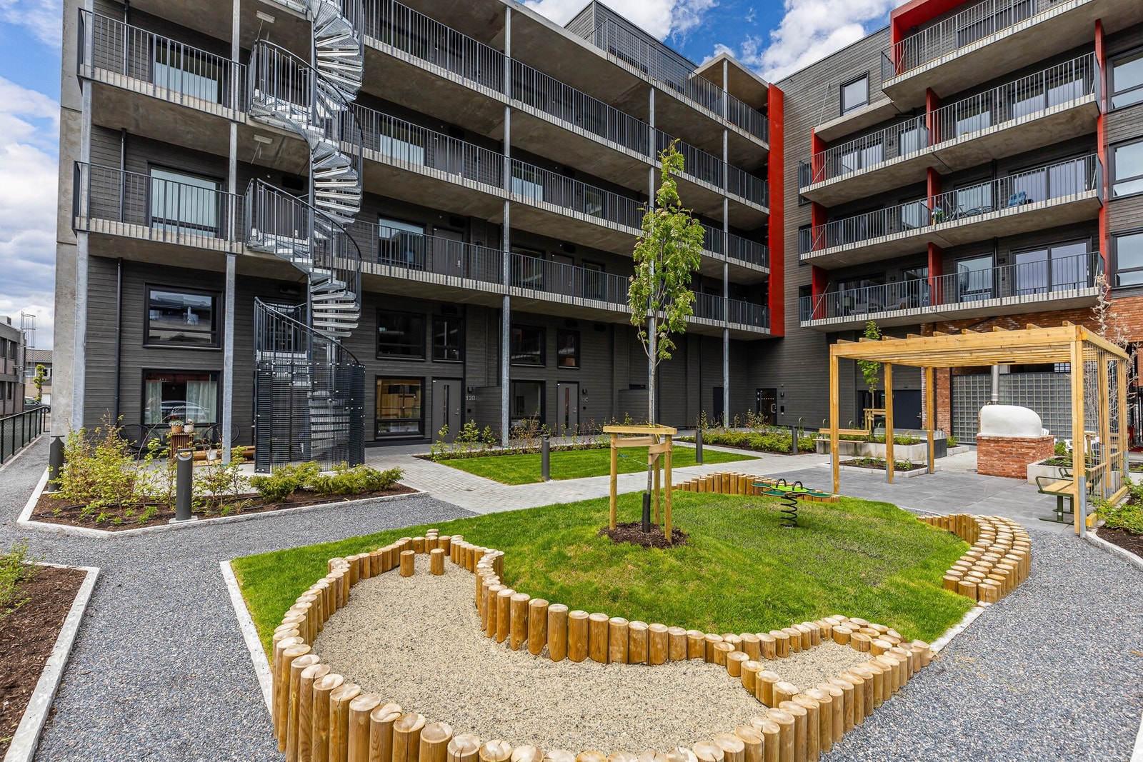 Her finner man også en sjarmerende pergola og flere soner med sittegrupper - perfekte for både avslapning og hyggelig samvær med naboer. Galleribilde