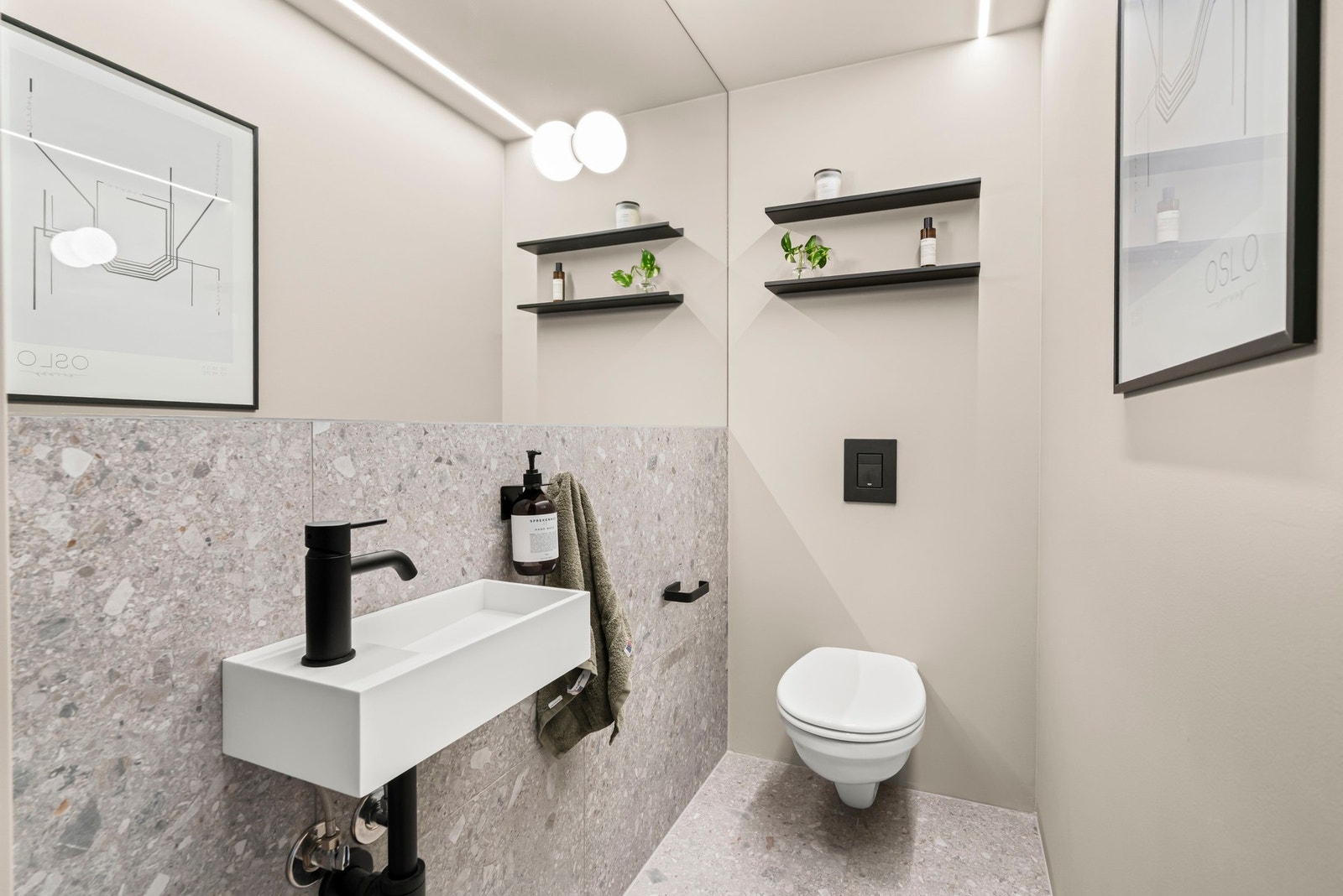 Smakfullt separat toalett med heldekkende speil og innebygd design lys fra Flos. Galleribilde