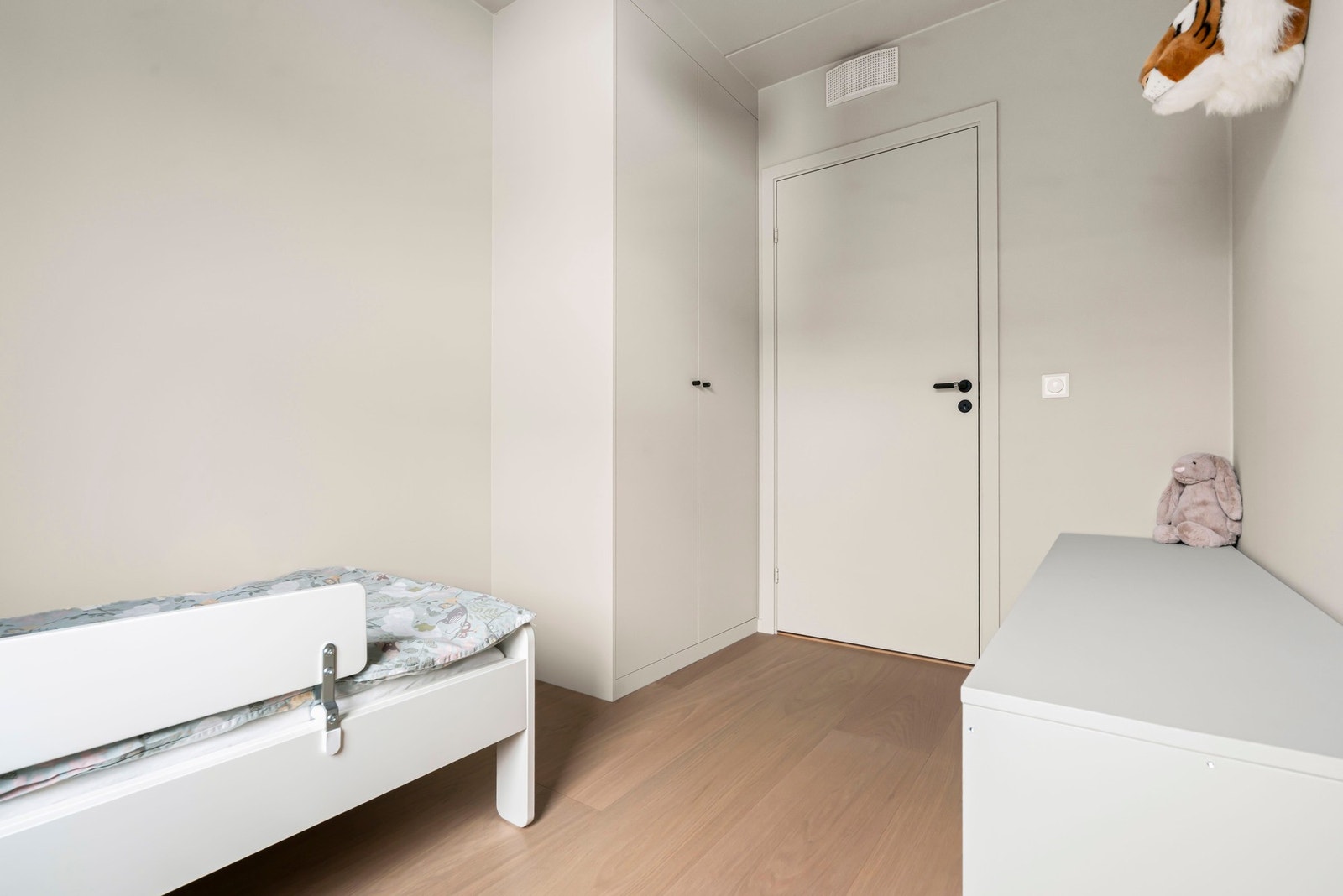 Oppbevaringsplass i fastmontert garderobe malt i samme farge som vegger. Galleribilde