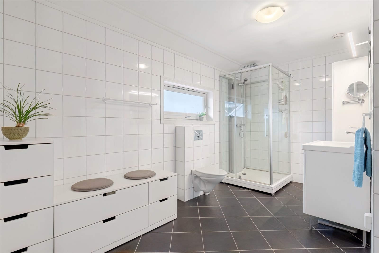 2. etg: Flott helfliset bad som er innredet med vegghengt toalett, dusjkabinett og baderomsinnredning med speil Galleribilde