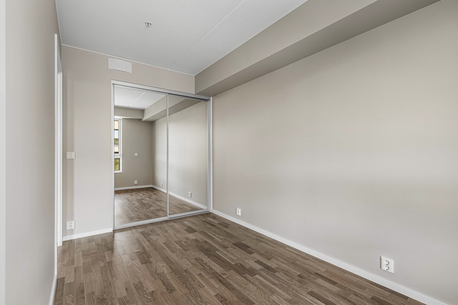 På endevegg er det større skyvedørsgarderobe med speilfronter - praktisk og gjør rommet større. Galleribilde