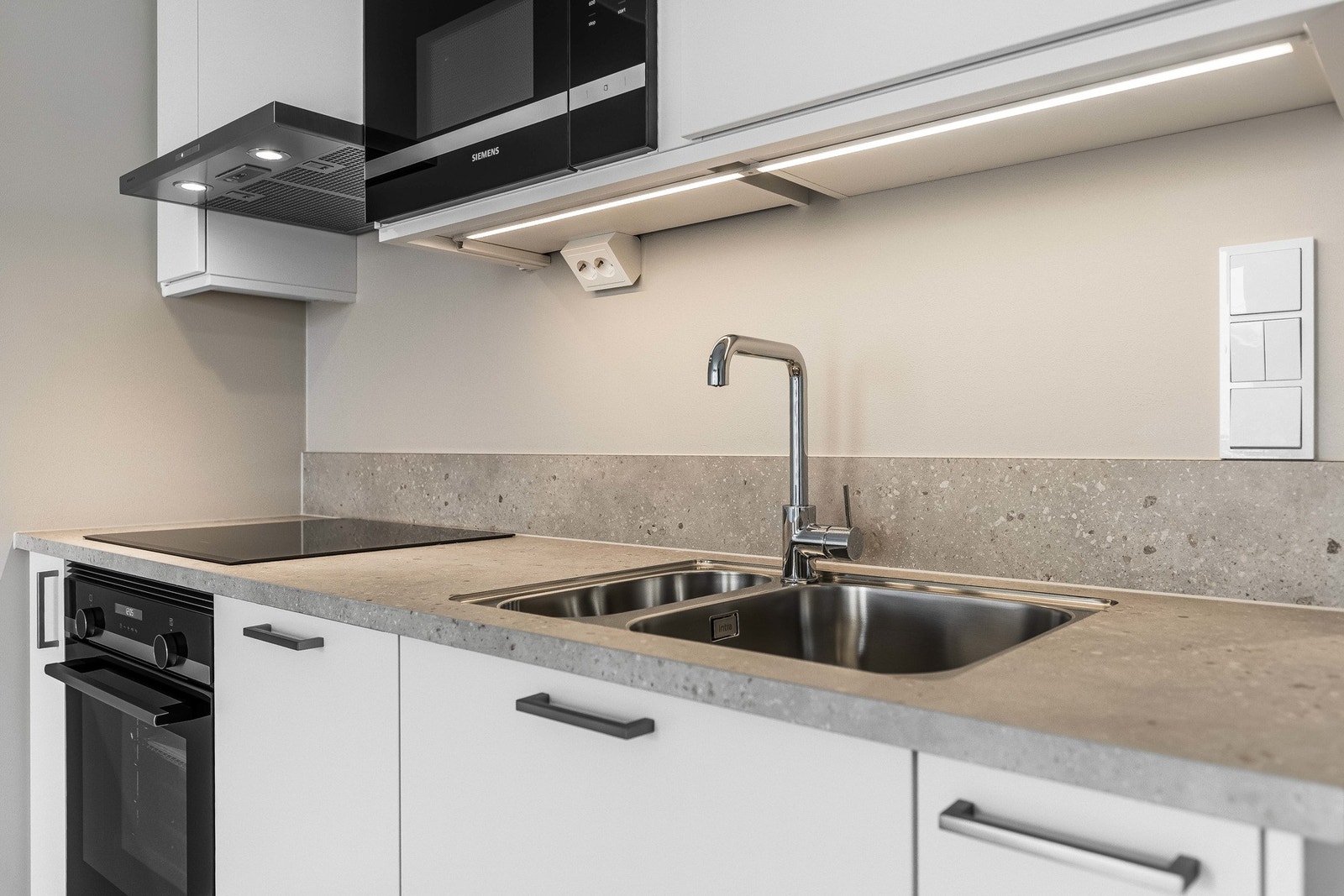 Videre er kjøkkenet utstyrt med integrerte hvitevarer som oppvaskmaskin, kjøleskap, stekeovn og koketopp, samt ventilator, benkestikk og god arbeidsbelysning. Galleribilde