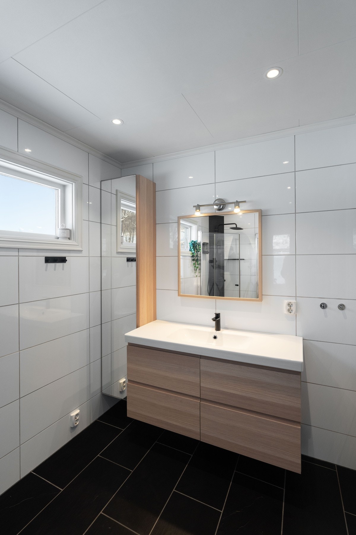 Badet har servantinnredning, toalett og dusj med dører i glass. Galleribilde