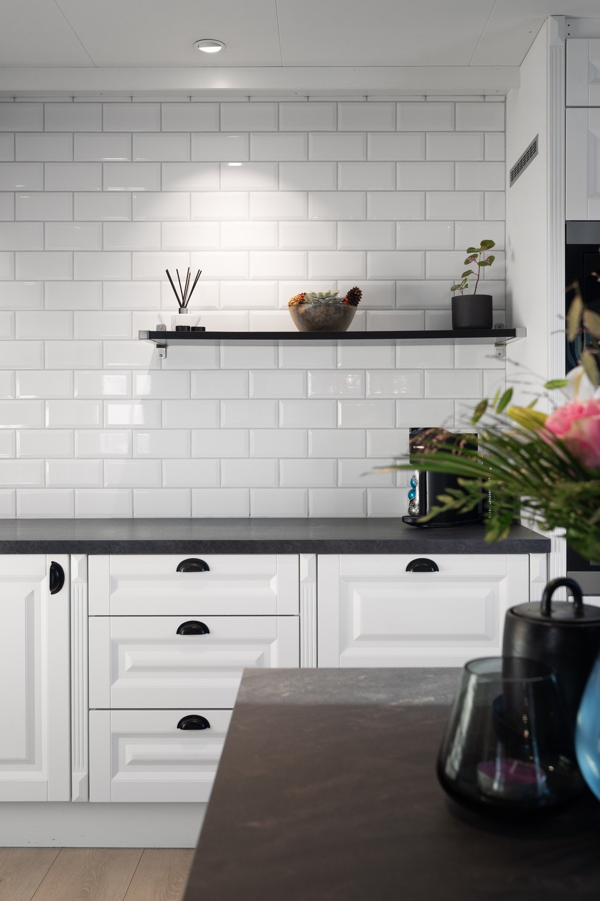 Hele veggen over benken og mellom over- og underskap er flislagt. Galleribilde