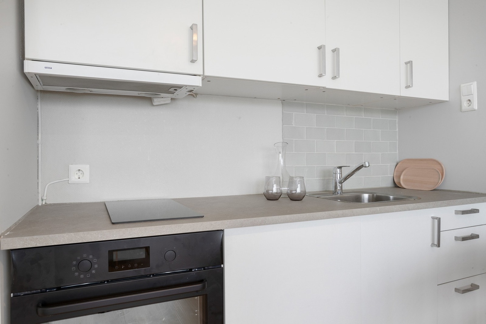 Nyere kjøkkeninnredning bestående av integrert komfyr og kjøleskap. Galleribilde