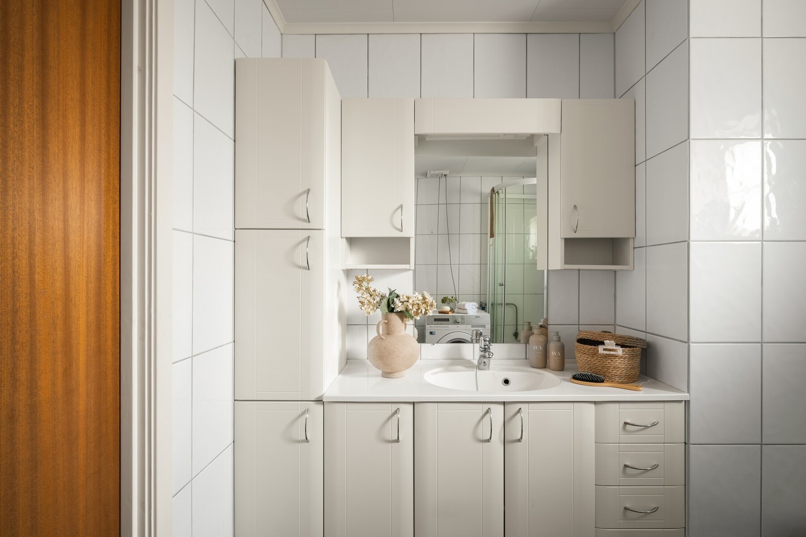 Stilren hvit innredning med nedfelt servant og godt med oppbevaringsplass. Galleribilde