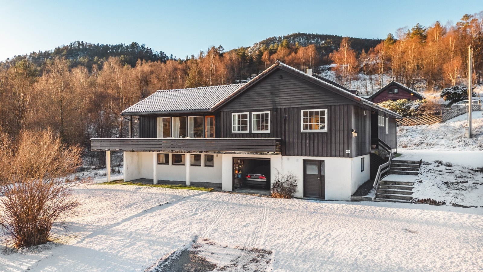 Eiendommen byr på store, sammenhengende hagearealer med gressplen, variert beplantning samt busker og trær som gir både grønne rammer og naturlig skjerming. Det lett skrånende terrenget er utnyttet på en god måte og skaper en harmonisk tomt med fine soner Galleribilde