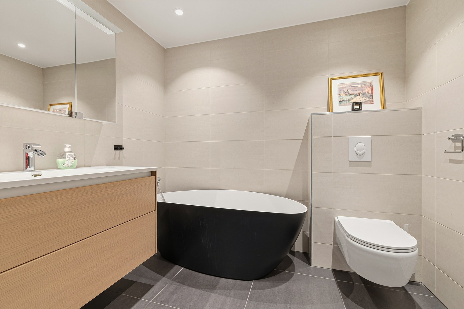 Her er både frittstående badekar og et dusjhjørne med innsvingbare dører i frostet glass. Galleribilde