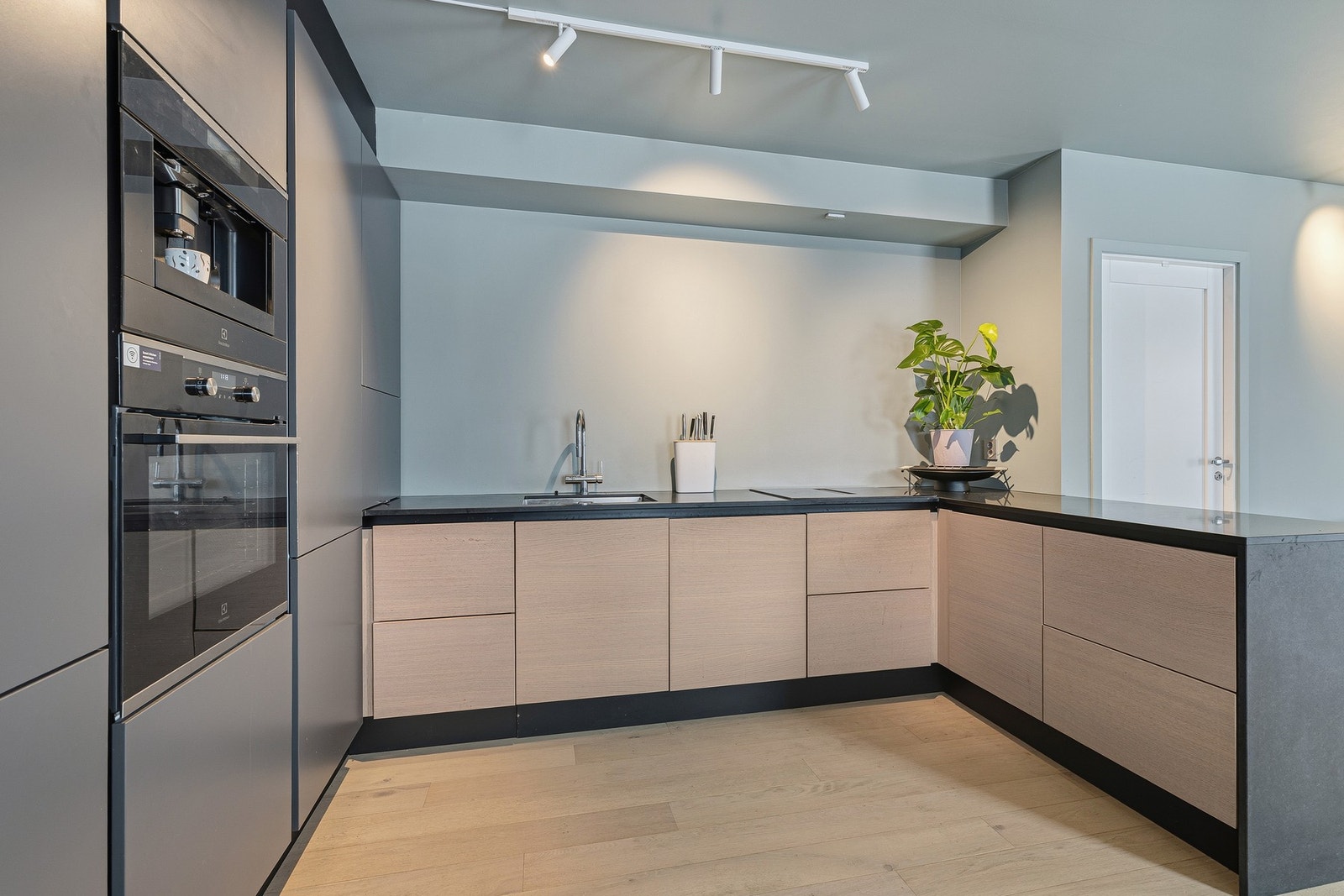 Kjøkkeninnredningen har glatte fronter, benkeplater av stein og oppvaskkum i stål. Her er rikelig oppbevaring både i hel skapvegg og benkeskap/skuffer. Galleribilde