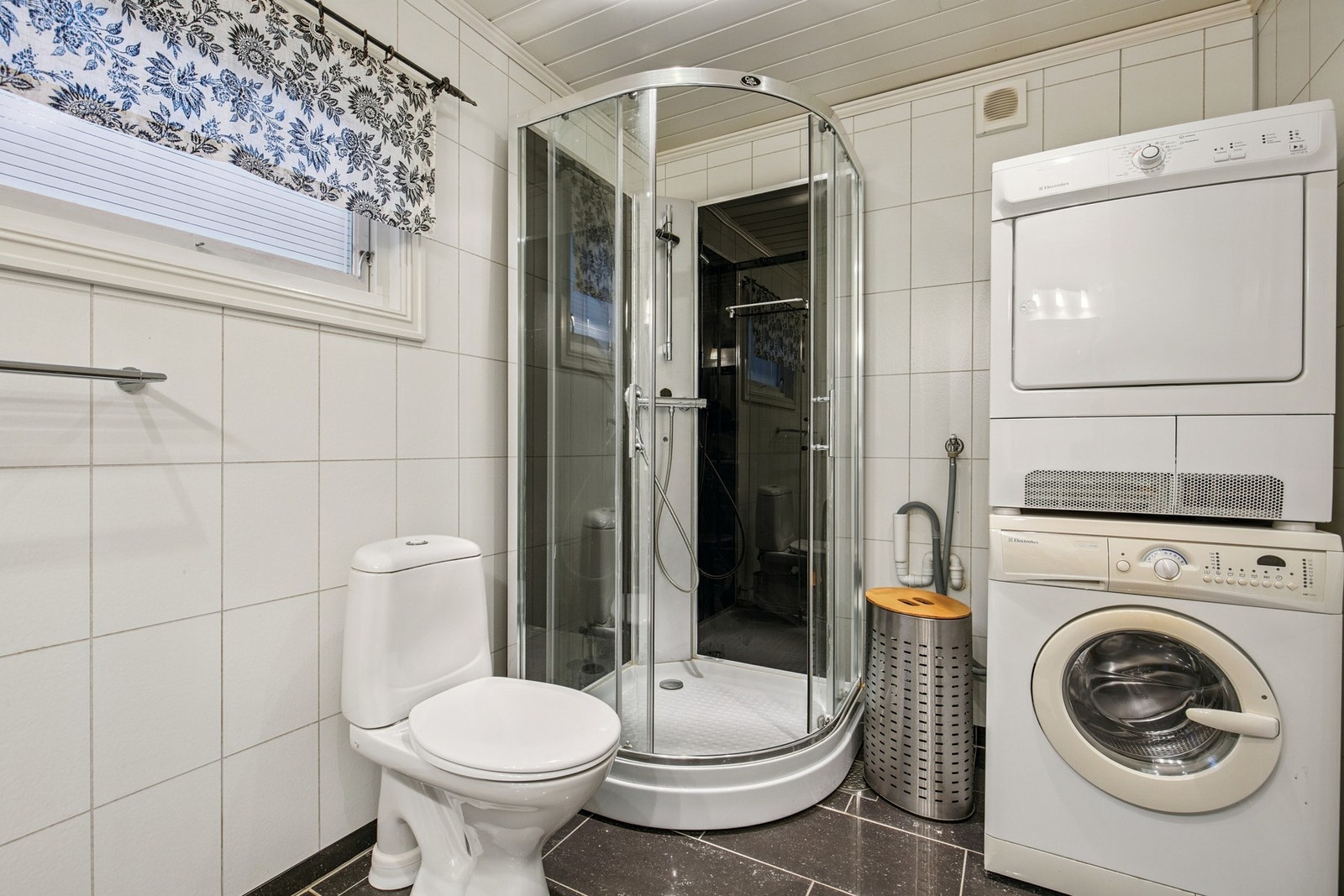 Badet har dusjkabinett og opplegg for vaskemaskin Galleribilde