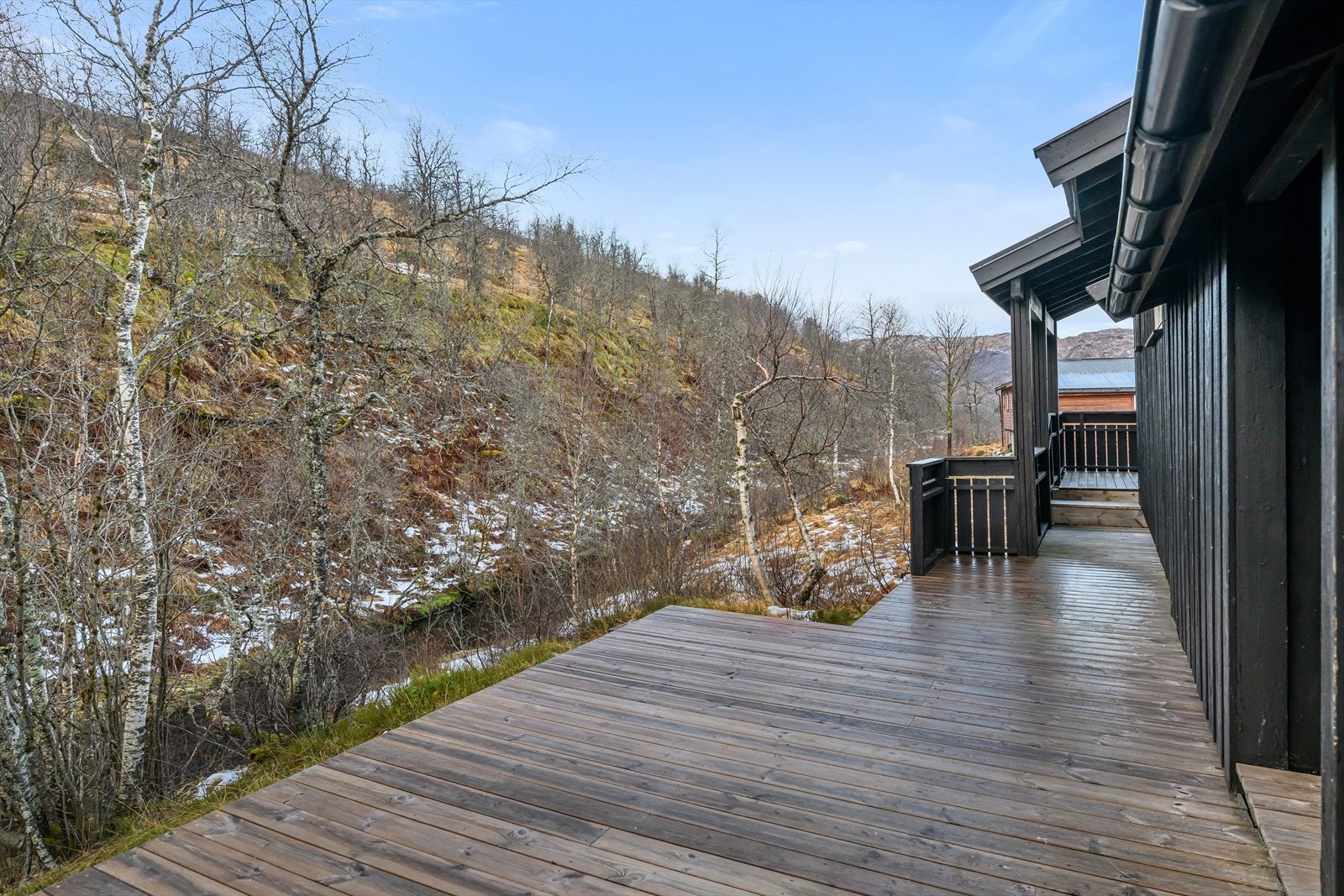 Terrassen på sørsiden av hytten. I "dalen" er det en liten elv. Galleribilde