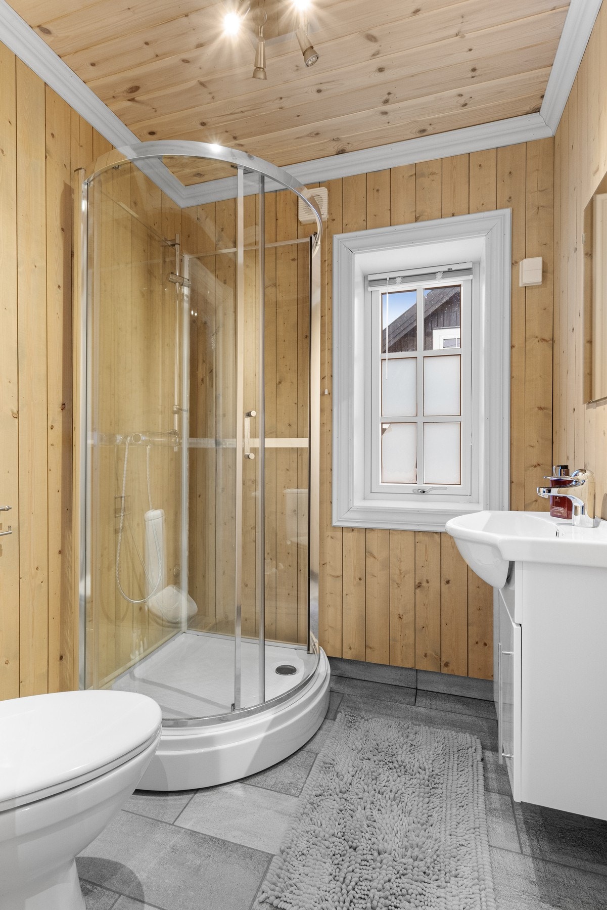 Baderom i 2.etasje inneholder dusjkabinett, toalett og innredning med servant. Her er det også flislagt gulv med varmekabler Galleribilde