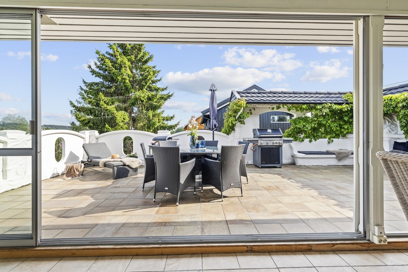 Terrassen er delvis skjermet og omkranset av frodig beplantning - en lun oase i det fri. Galleribilde