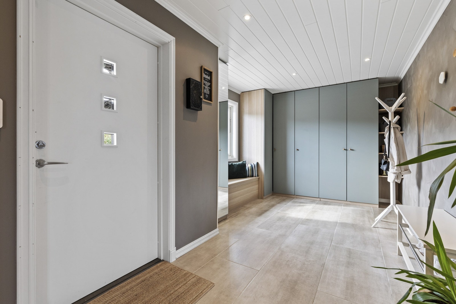 En innbydende start på hjemmet, med fliser, varme i gulvet og god plass til yttertøy. Foto Marika Foto AS Galleribilde