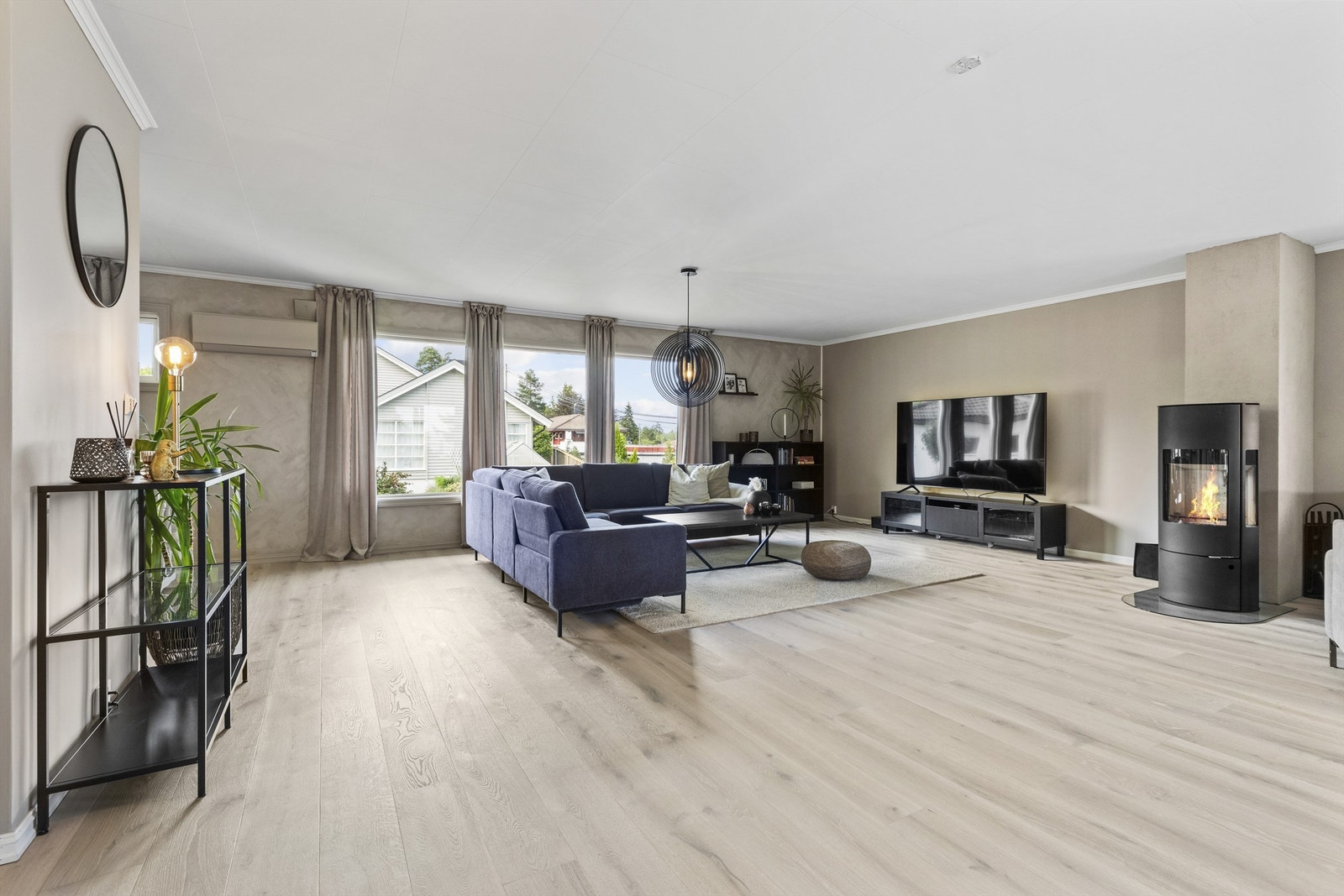 Lys og romslig stue med peisovn og god plass til både sofagruppe og spisebord. Galleribilde