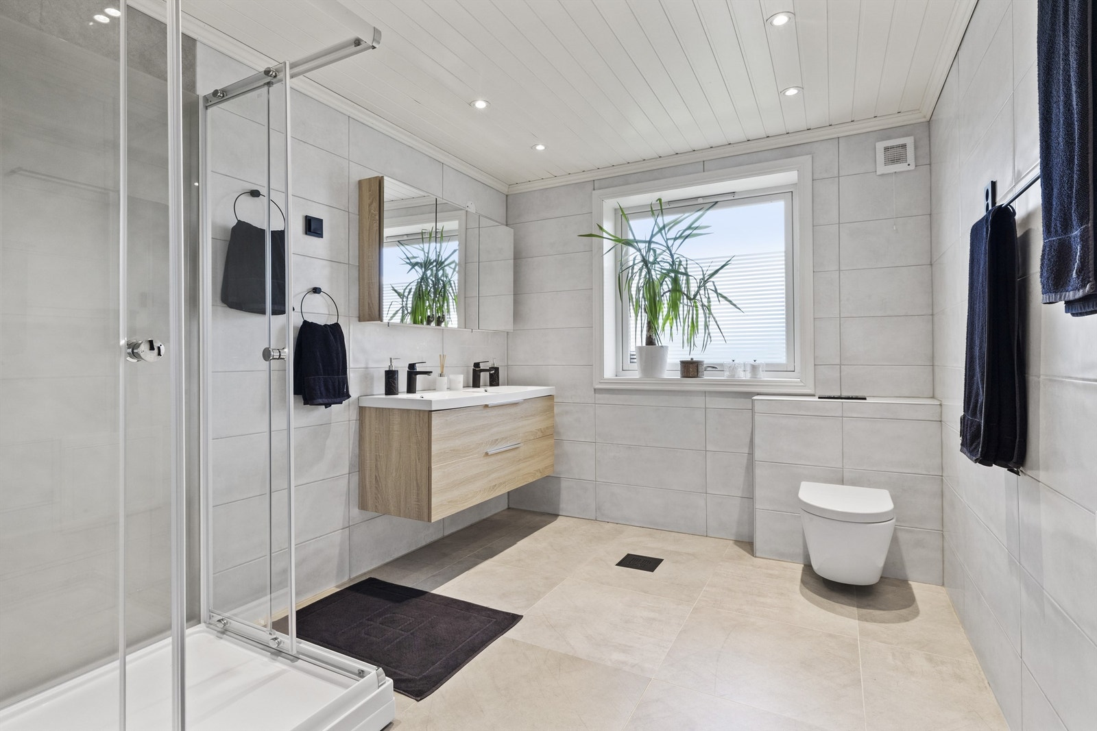 Lyst bad med dobbel servant, gulvvarme og moderne løsninger. Galleribilde