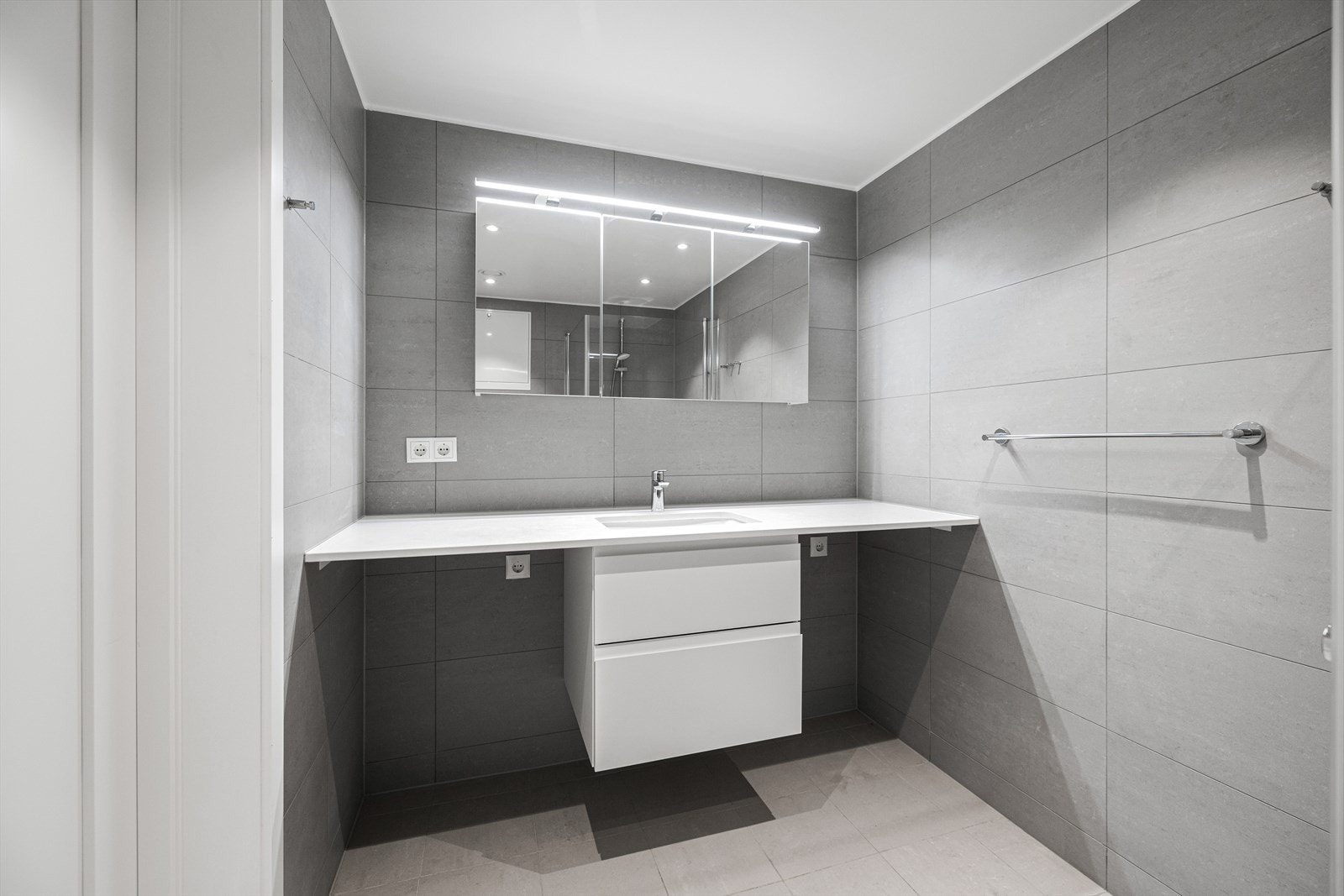 Opplegg for vaskemaskin og tørketrommel, lys over speil og rikelig med skuffeplass Galleribilde