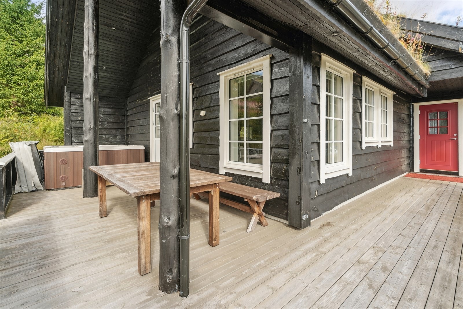 Hytta har ei stor naturtomt og ein romsleg, delvis overbygd, terrasse Galleribilde