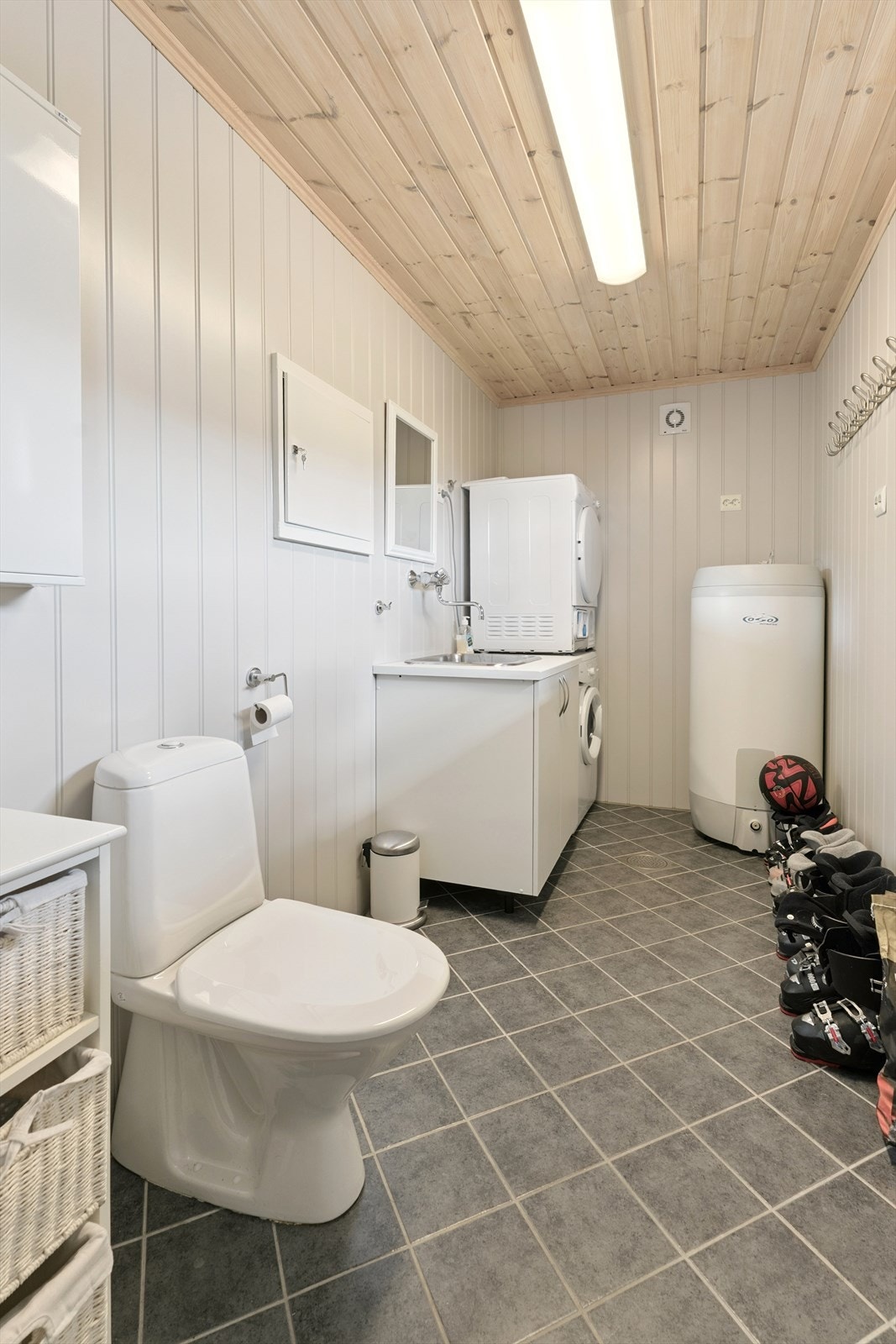 Vaskerommet ligg rett ved entréen.
Det er flislagt golv med varmekablar. Malte plater på vegg. Her er det opplegg for vask/tørk samt arbeidsbenk. Ekstra toalett. Galleribilde