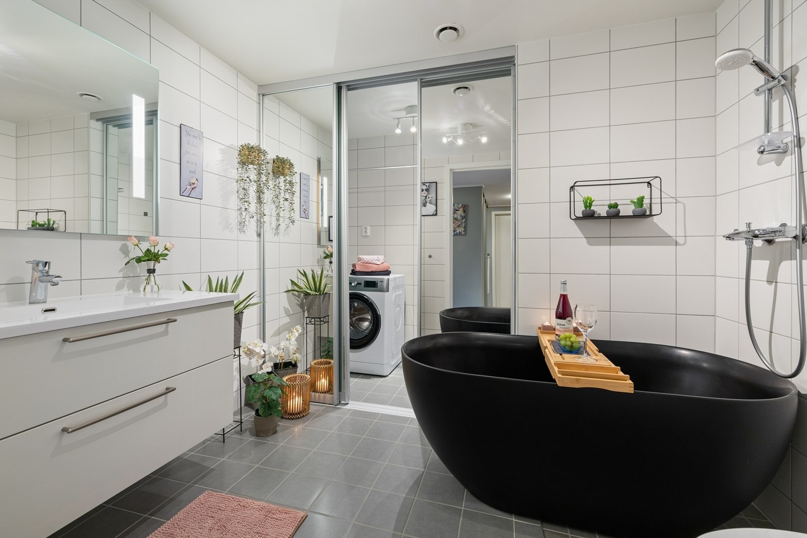 Flislagt baderom/vaskerom med gulvvarme. Her er det opplegg for vaskemaskin og tørketrommel som er praktisk skjult bak skyvedører av speil. Galleribilde