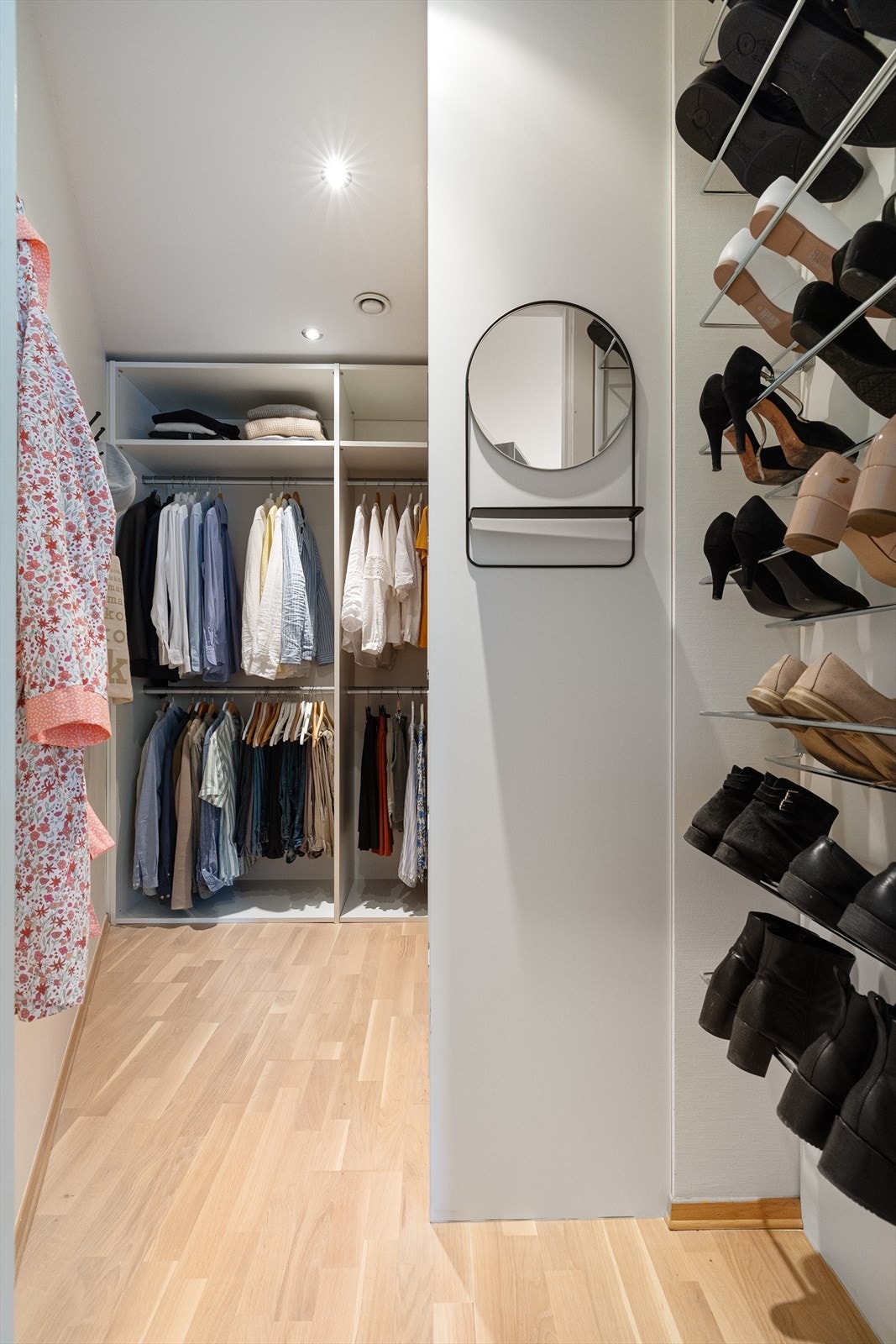 Walk-in garderoben er innredet med skap, hyller og skuffer Galleribilde