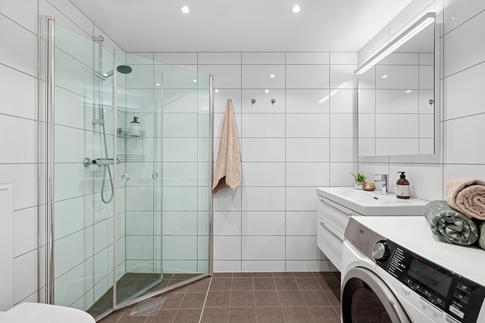 Delikat bad med benkeskap med glatte fronter og servant i helstøpt plate. Galleribilde