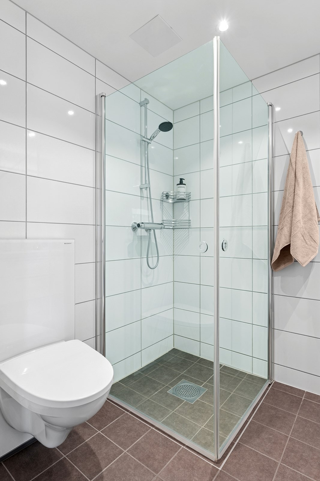 Badet er utstyrt med dusj med dører i herdet glass, klosett og opplegg for vaskemaskin. Galleribilde