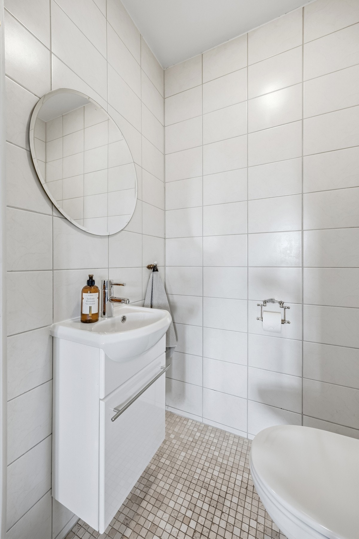 Videre har toalettrommet vegghengt servantskap, speil over servant og vegghengt toalett. Galleribilde