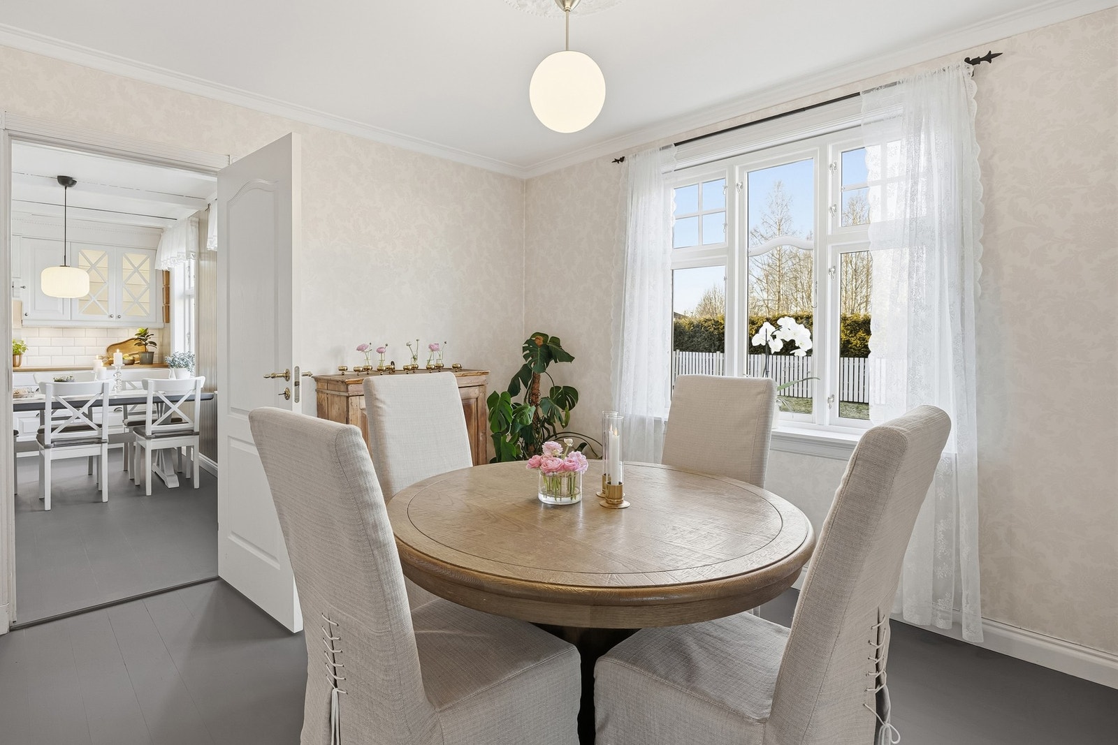 Doble fløydører gir et klassisk og stilfullt uttrykk, mens det store vindu slipper inn rikelig med naturlig lys og skaper en lys og luftig atmosfære - ideelt for både hverdagsmåltider og sosiale sammenkomster. Galleribilde