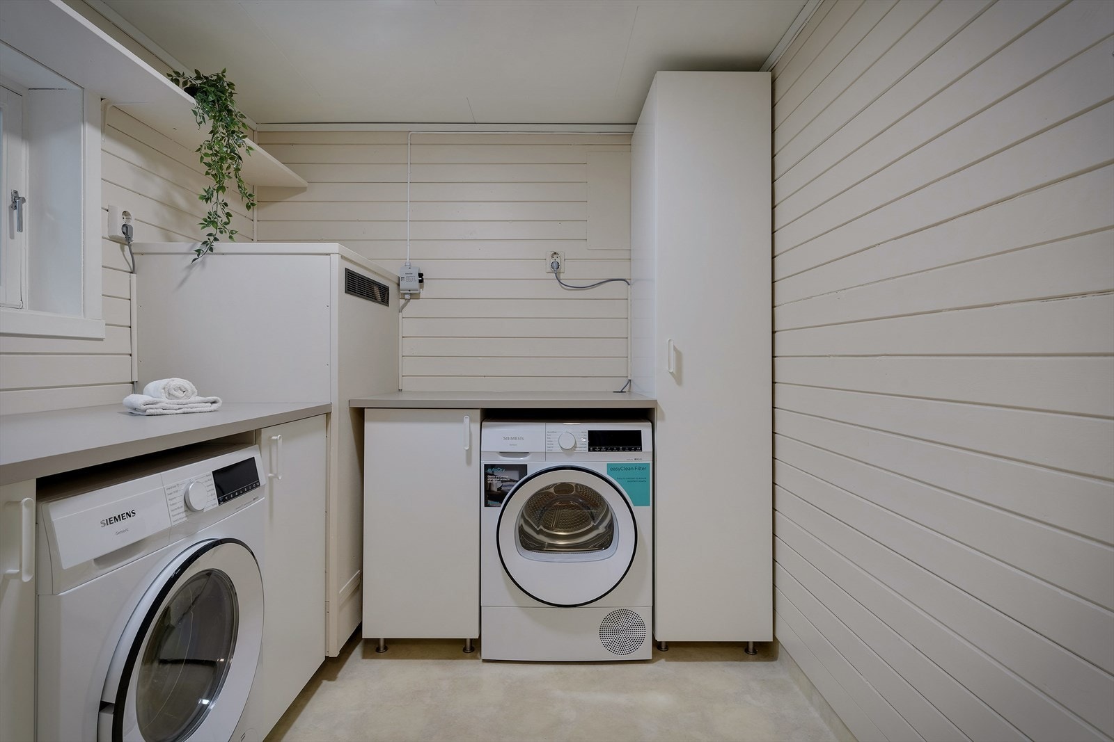 Praktisk vaskerom med opplegg for vaskemaskin og tørketrommel. Galleribilde