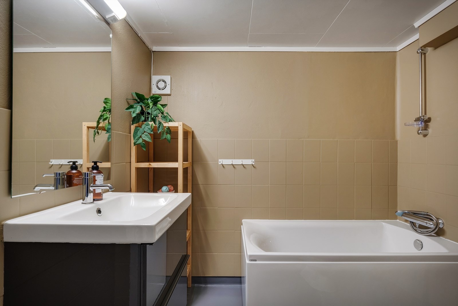 Badet i kjelleren er innredet med badekar, innredning med nedfelt servant og toalett. Galleribilde