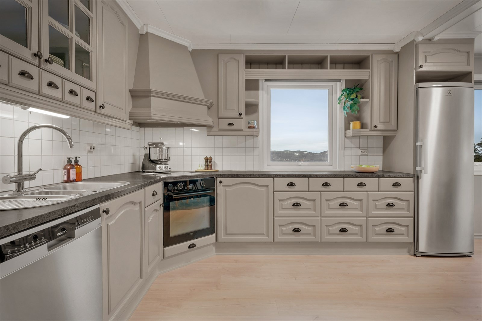 Pent og tidløst kjøkken med profilerte fronter og foliert, heltre benkeplate. Galleribilde