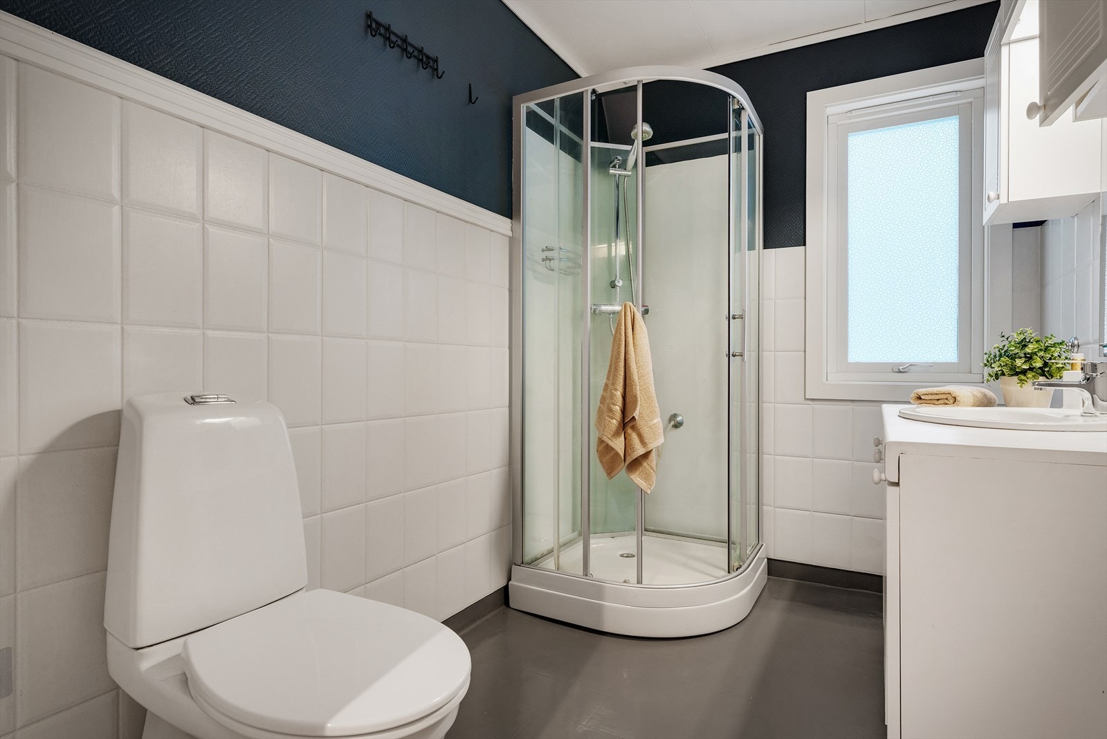 Fint bad innredet med dusjkabinett, toalett og innredning med nedfelt servant. Galleribilde