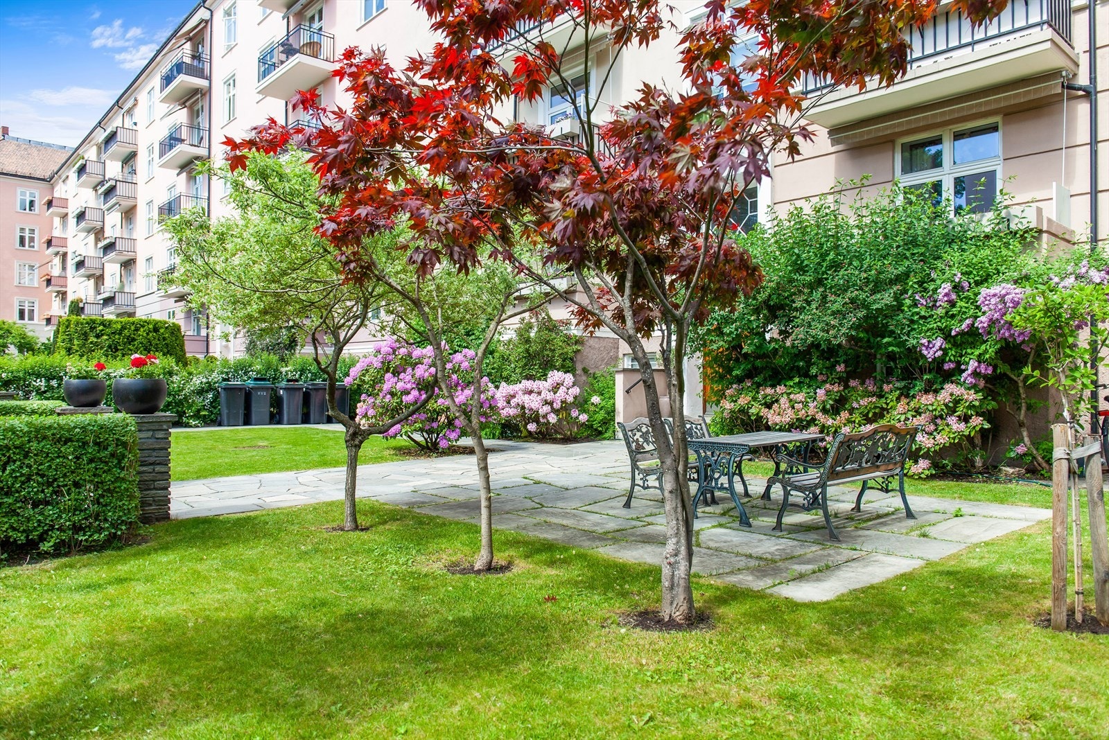 Forhage og inngangsparti som ligger et nivå opp fra gate, med felles sittegruppe til glede for beboerne. Galleribilde