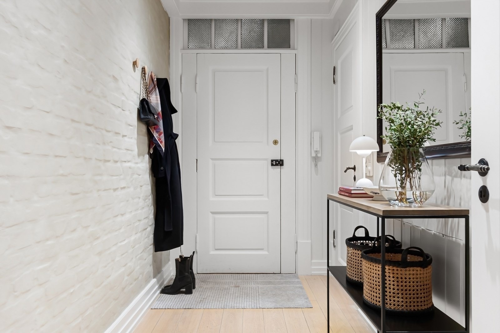 Lys og innbydende entré med vegg av malt teglstein. Galleribilde