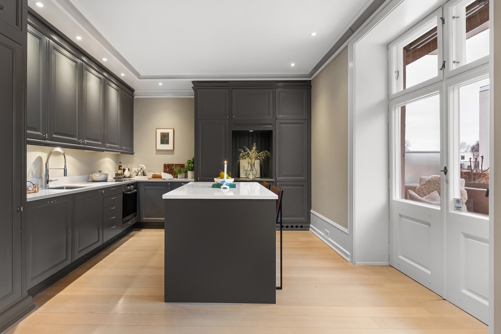 Romslig, velutstyrt og plassbygget kjøkken med profilerte fronter og benkeplate i steinkompositt (kvarts). Galleribilde