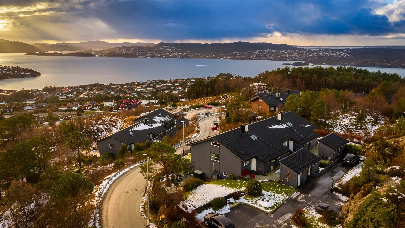Rekken ligger fint hevet over veien i front uten innsyn til hage og med en fabelaktig utsikt. Felles parkering like ved husrekken Galleribilde