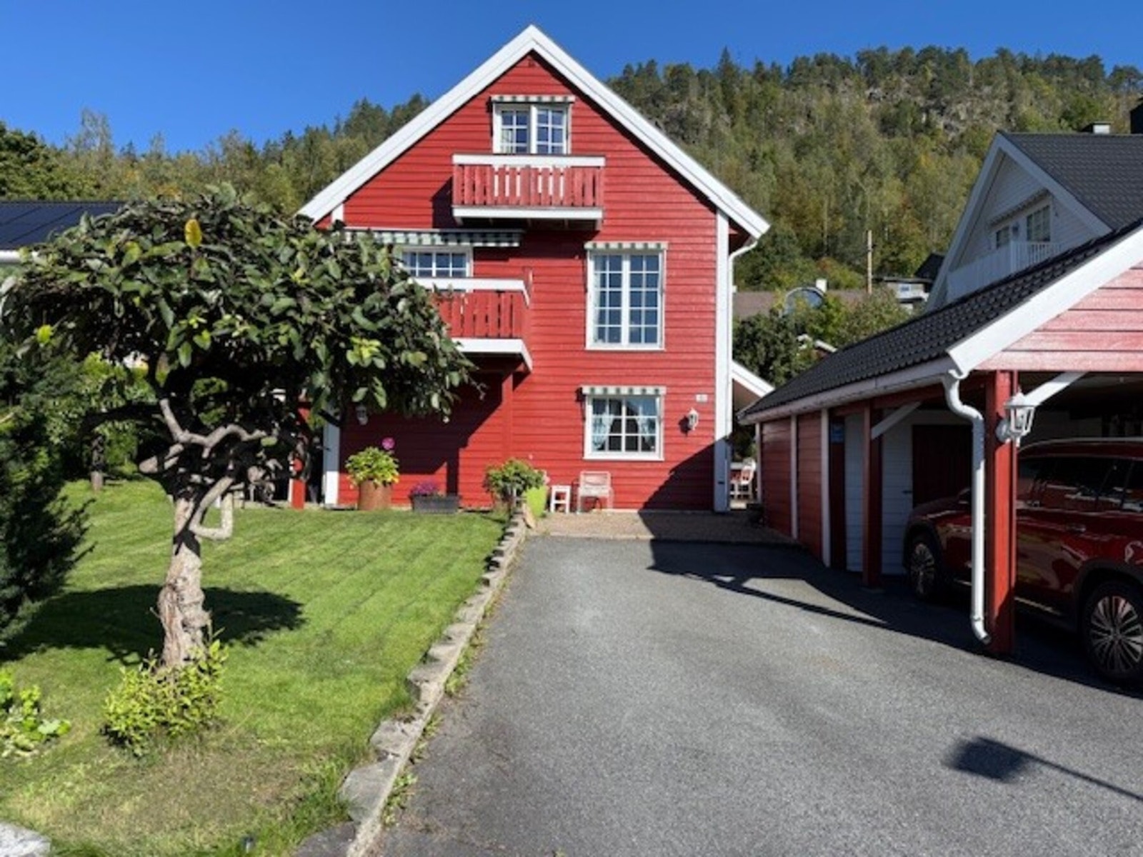 Parkering gjøres i carport med en parkeringsplass med elbillader og to boder. Galleribilde