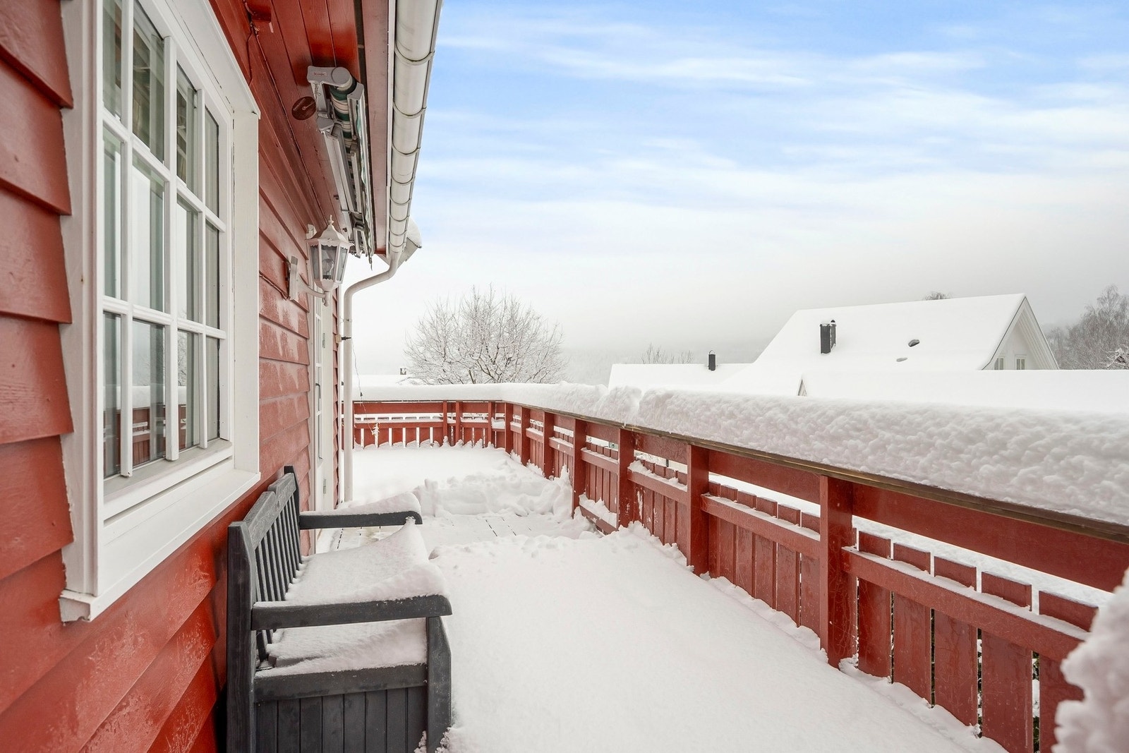 Balkongen ble oppgradert i 2024 med nye terrassebord og strekker seg rundt tre av boligens sider. Galleribilde