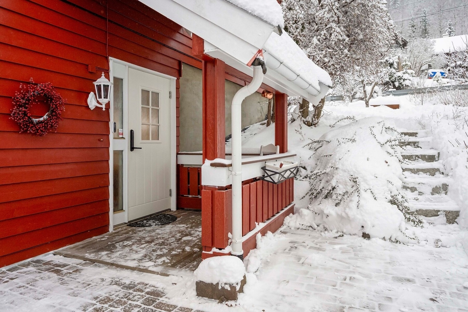 Adkomst gjøres via et hyggelig, overbygget inngangsparti. Boligen en hellelagt uteplass med trapp som tar deg videre til den frodige hagen. Galleribilde