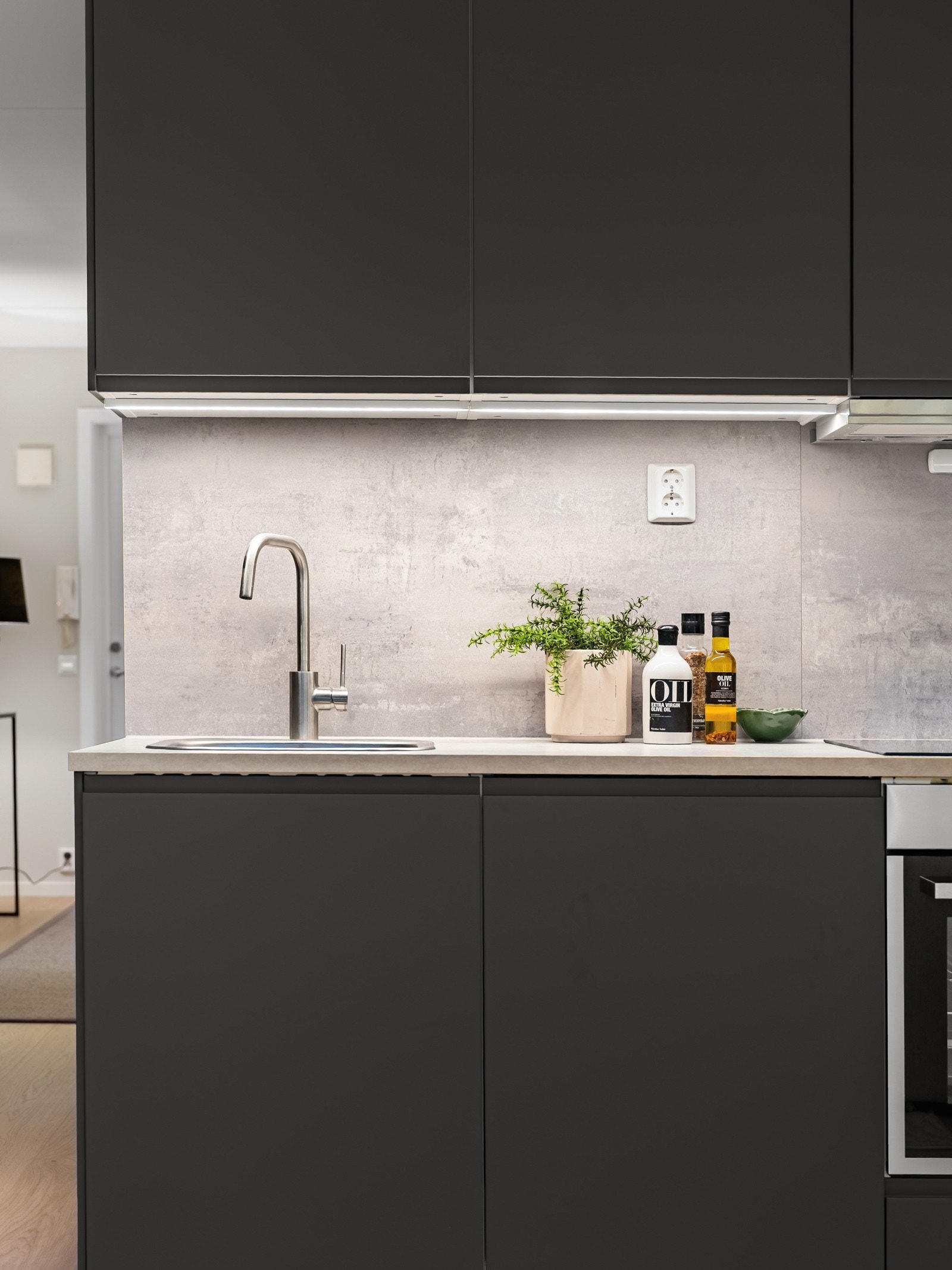 Ny og pen innredning med glatte folierte fronter, benkeplate av laminat og nedfelt oppvaskkum i rustfritt stål. Galleribilde