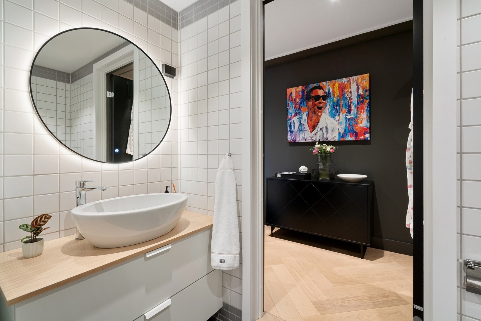 Underskap med skuffer, armatur til vask, stikkontakter og speil med belysning er montert i 2025. Sort dør fra entré med håndtak og låsvrider fra Buster + Punch London. Galleribilde