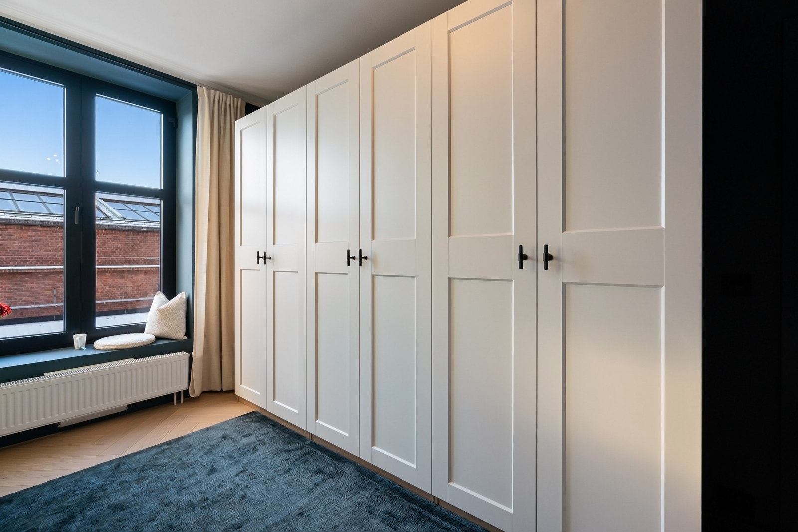 Garderobeskapene har hvite profilerte fronter, håndtak fra Buster + Punch London, og PAX innredning med skuffer og heng. Galleribilde