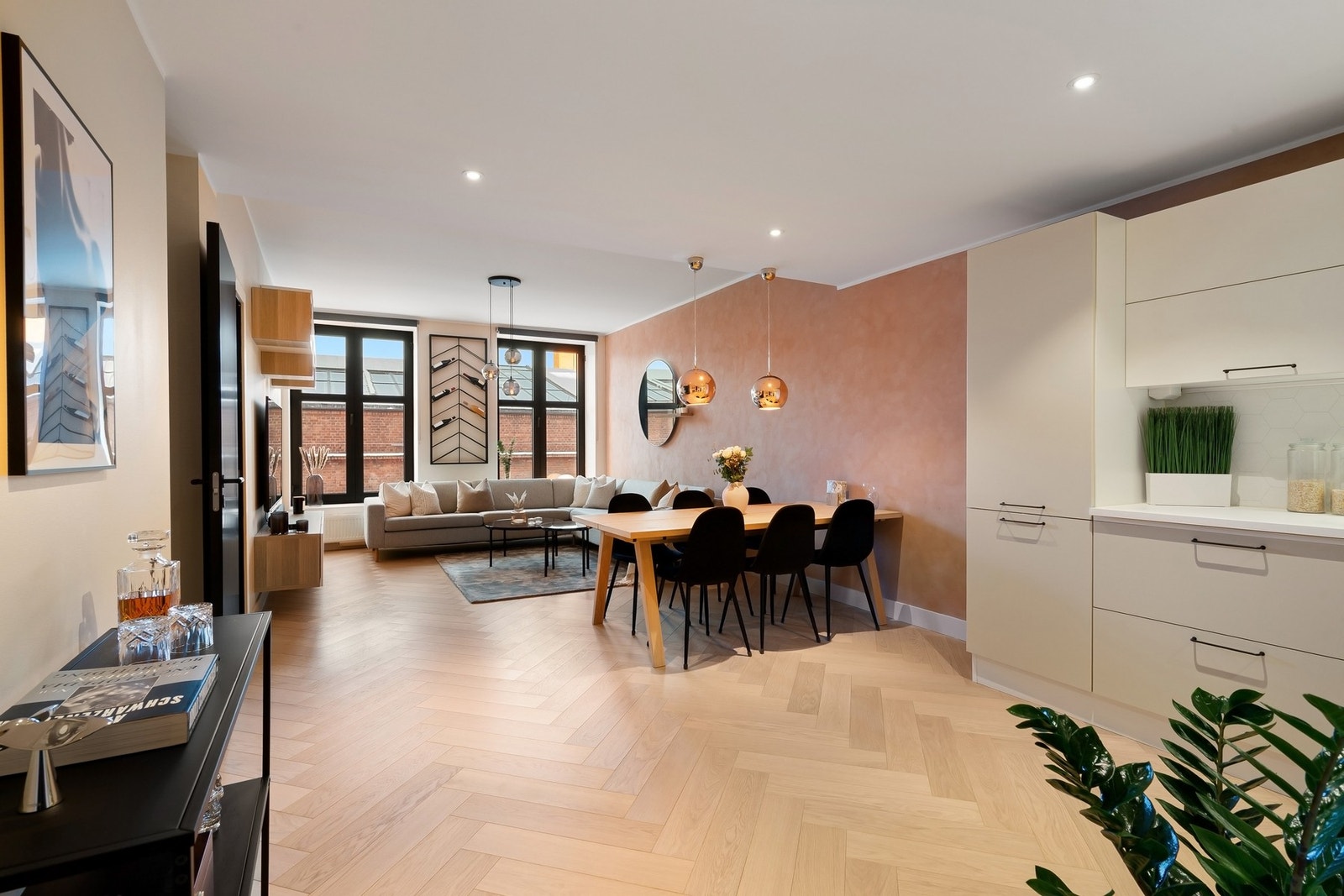 Stuen fremstår som romslig, lys og sosial med takhøyde på opptil 2,75 meter i ytterste del. Rommet har god plass til både stor sofagruppe og spisebord. På gulvet har man bred fiskebensparkett i eik. Galleribilde