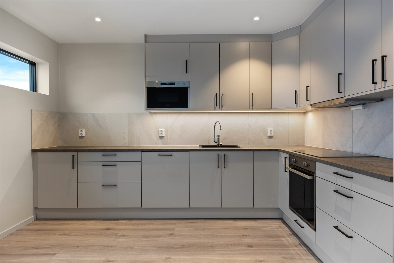 Kjøkken med integrerte hvitevarer og takhøye skap. Galleribilde