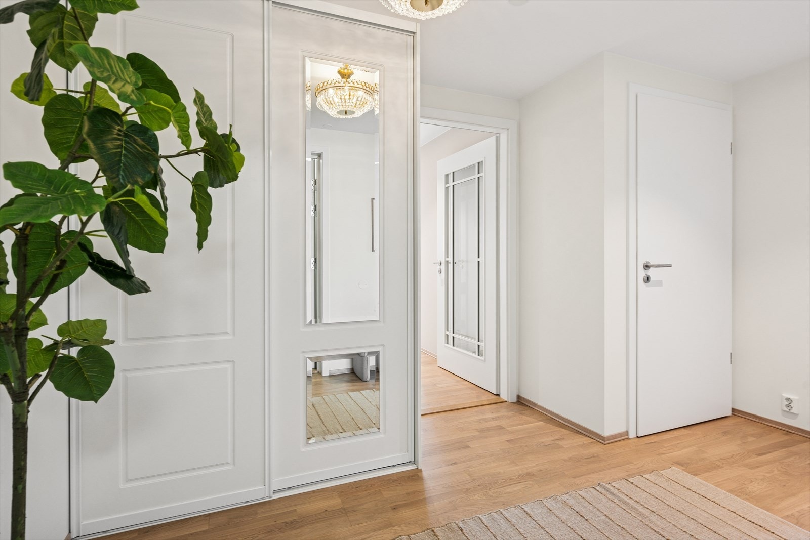 Entreen til leiligheten er gjennomført med parkett på gulvet, samt lyse og behagelige farger på vegger og tak. Galleribilde