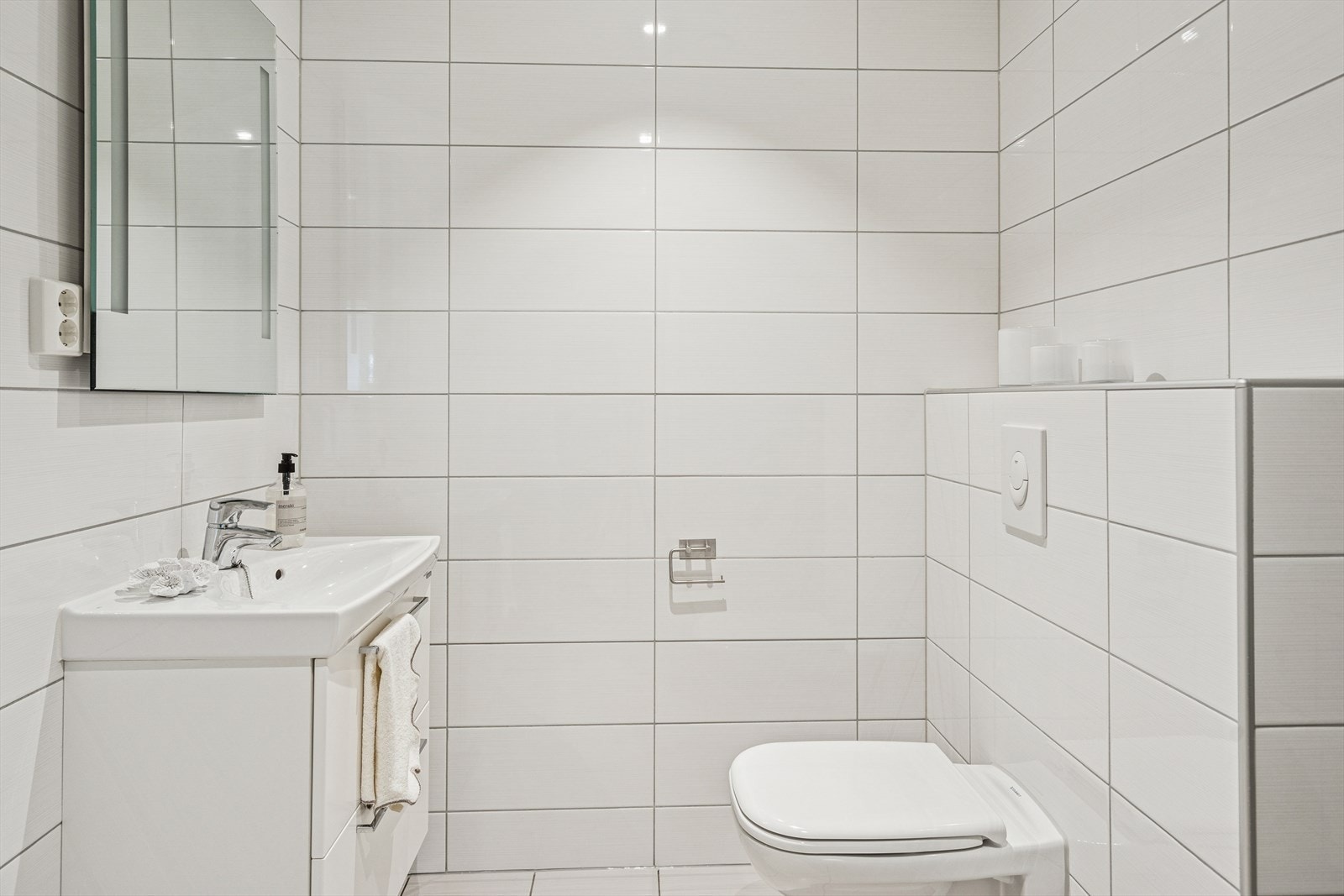 Lekkert og romslig kombinert vaskerom og toalettrom som er pent gjennomført med flislagt gulv og vegger. Galleribilde